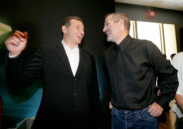 Walt Disney Company CEO Bob Iger (left) and Pixar CEO Steve Jobs (right) shake hands after announcin