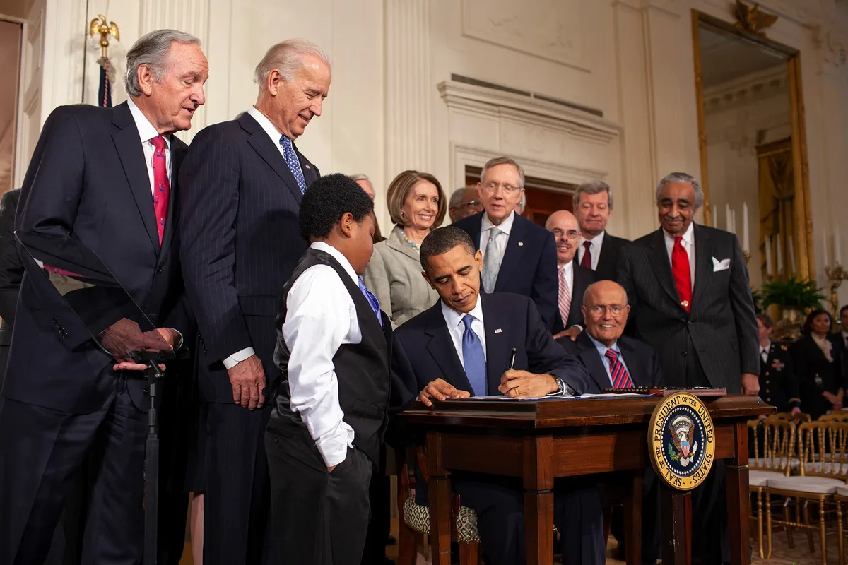President Barack Obama signs the Affordable Care Act (ACA) into law on March 23, 2010, at the White 
