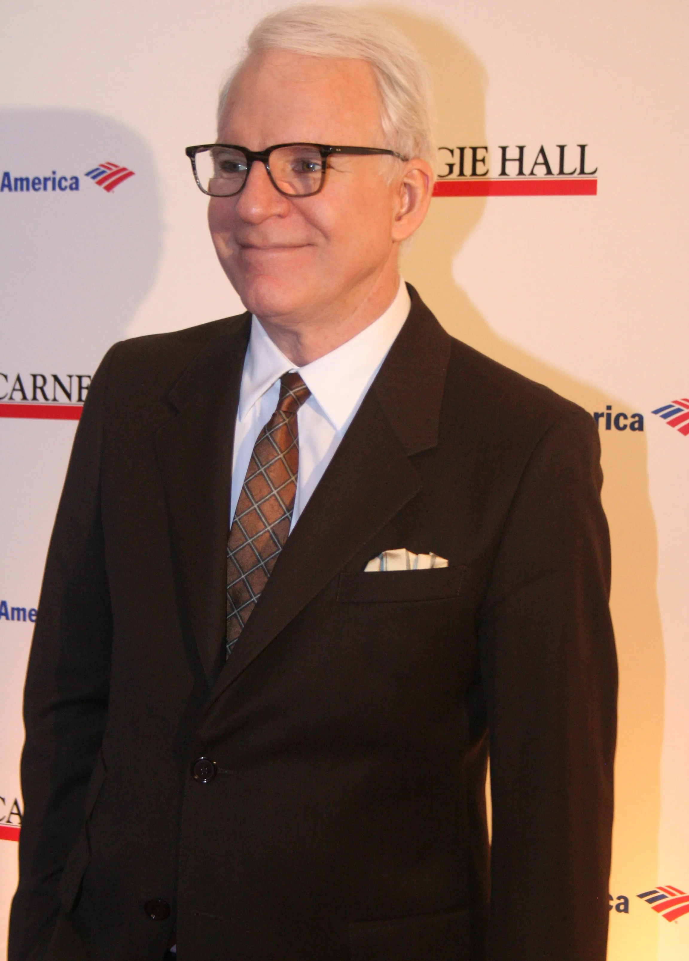 Steve Martin at Carnegie Hall, wearing glasses and a dark suit