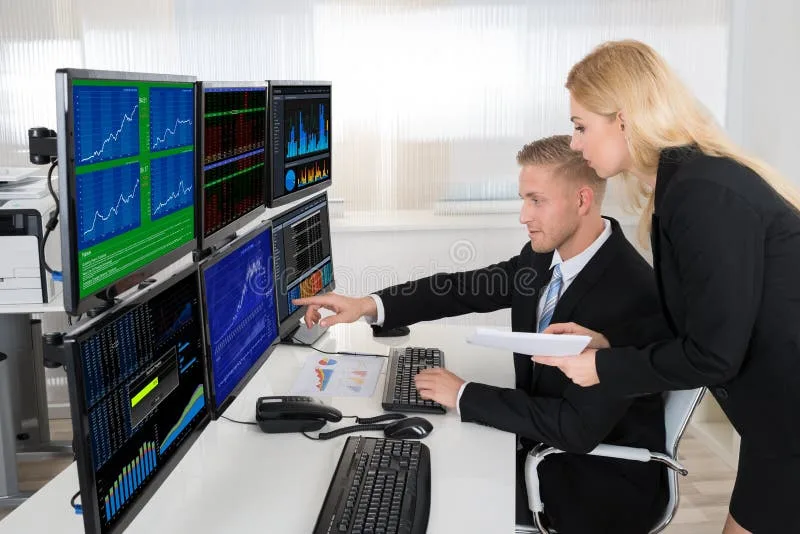 A modern financial trading desk, often featuring multiple screens displaying real-time data and comp